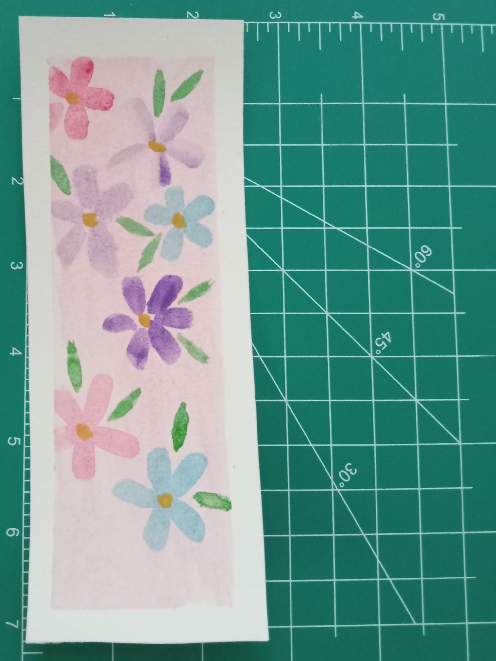 Floral design on a piece of paper with a green cutting mat in the background