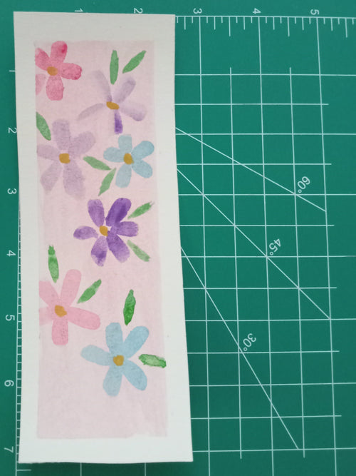 Floral design on a piece of paper with a green cutting mat in the background